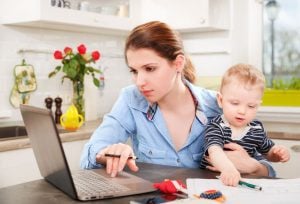 53061475 - young mother working with her baby at home